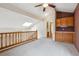 Upstairs loft area with carpet and built-in cabinets, plus natural light from skylight at 8563 Redstone St, Highlands Ranch, CO 80126