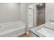 Modern bathroom with granite countertops, soaking tub, glass shower, and walk-in closet at 2134 Alyssa St, Fort Lupton, CO 80621