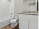 Bright bathroom featuring a granite countertop, wood flooring, and a tiled shower and bath at 2134 Alyssa St, Fort Lupton, CO 80621