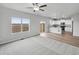 Open-concept living room with large windows, connecting to the kitchen and dining area at 2134 Alyssa St, Fort Lupton, CO 80621