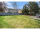 Large grassy backyard with a tall wood fence and mature trees at 5607 S Gray St, Littleton, CO 80123
