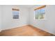 Inviting bedroom with hardwood floors, neutral paint, and two large windows with bright views at 5607 S Gray St, Littleton, CO 80123