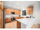 Kitchen with quartz counters, stainless appliances, wooden cabinets, and tile floors at 5607 S Gray St, Littleton, CO 80123