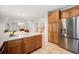 Spacious kitchen with stainless steel refrigerator, oak cabinets, white countertops, and tile floor at 5607 S Gray St, Littleton, CO 80123