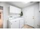 Convenient laundry area with washer, dryer, cabinets, and tile floor at 5607 S Gray St, Littleton, CO 80123