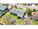 An aerial view of the home with its new gray roof, landscaping, yard and fenced backyard with a greenhouse at 5747 W Elmhurst Ave, Littleton, CO 80128
