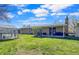 Spacious backyard featuring a greenhouse, covered patio, and well-maintained lawn at 5747 W Elmhurst Ave, Littleton, CO 80128