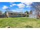 Spacious backyard featuring a lush lawn, mature trees, a greenhouse, and plenty of room for outdoor activities at 5747 W Elmhurst Ave, Littleton, CO 80128