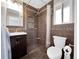 Bathroom with dark tiled shower, vanity, and modern fixtures at 5747 W Elmhurst Ave, Littleton, CO 80128