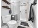 This bathroom includes a walk-in shower, gray vanity with a modern sink, and a floating wood shelf for towels at 5747 W Elmhurst Ave, Littleton, CO 80128