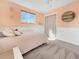 This cute bedroom offers light peach paint, wainscoting, carpet, and a window for lots of natural light at 5747 W Elmhurst Ave, Littleton, CO 80128