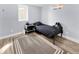This bedroom features light walls, a small window, a twin bed, a neutral carpet, and a floating shelf at 5747 W Elmhurst Ave, Littleton, CO 80128