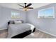 Serene bedroom with light blue walls, ceiling fan, and windows providing natural light at 5747 W Elmhurst Ave, Littleton, CO 80128
