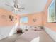 This bedroom features light peach paint, white wainscoting, a ceiling fan, carpet, and a window for natural light at 5747 W Elmhurst Ave, Littleton, CO 80128