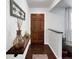 Welcoming foyer with wood-look floors, decorative shelf, and view of a wooden front door at 5747 W Elmhurst Ave, Littleton, CO 80128