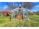 Backyard greenhouse with weathered glass and a small, gated door stands on a well-manicured lawn at 5747 W Elmhurst Ave, Littleton, CO 80128