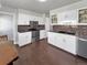Bright kitchen featuring white cabinets, dark countertops, and stainless steel appliances at 5747 W Elmhurst Ave, Littleton, CO 80128