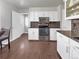 Well-lit kitchen featuring stainless steel appliances, stone countertops, and white cabinetry at 5747 W Elmhurst Ave, Littleton, CO 80128
