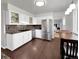 Bright kitchen with white cabinets, stainless steel appliances, and a dining area at 5747 W Elmhurst Ave, Littleton, CO 80128