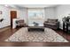 Cozy living room featuring wood-look floors, a neutral rug, and a bright front window at 5747 W Elmhurst Ave, Littleton, CO 80128
