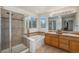 Bright bathroom featuring a glass enclosed shower, soaking tub, and double sink vanity at 11973 Song Bird Hills St, Parker, CO 80138