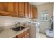 Efficient laundry room with oak cabinets, sink, and modern washer and dryer at 11973 Song Bird Hills St, Parker, CO 80138