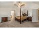 Spacious main bedroom featuring a dark wood four poster bed and neutral carpeting at 11973 Song Bird Hills St, Parker, CO 80138
