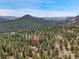 Aerial shot of a home nestled in a forest with mountain views at 3726 Spring Valley Trl, Evergreen, CO 80439