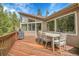 View of a wooden deck with an outdoor dining set and grill at 3726 Spring Valley Trl, Evergreen, CO 80439