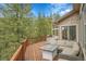 Spacious outdoor deck with a dining area, seating and wooded views at 3726 Spring Valley Trl, Evergreen, CO 80439
