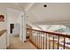 Open hallway showcases access to rooms, an overlook, and beautiful kitchen lighting at 3726 Spring Valley Trl, Evergreen, CO 80439