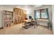 Well lit home office with a wooden accent wall, built in shelving, and great natural light at 3726 Spring Valley Trl, Evergreen, CO 80439