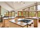 Kitchen area offers center island with cooktop, natural wood cabinetry, and ample windows with beautiful views at 3726 Spring Valley Trl, Evergreen, CO 80439