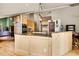 Modern kitchen boasts light wood cabinets, center island with seating, and hardwood floors throughout at 3726 Spring Valley Trl, Evergreen, CO 80439