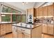 Open concept kitchen showcases stainless steel appliances, center island, and large windows with wooded views at 3726 Spring Valley Trl, Evergreen, CO 80439