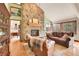 Spacious living room with a stone fireplace, a leather sofa set, and hardwood floors at 3726 Spring Valley Trl, Evergreen, CO 80439