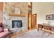 Cozy living room boasts a stone fireplace, hardwood floors, and a wood-burning stove at 3726 Spring Valley Trl, Evergreen, CO 80439