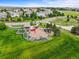 An aerial view shows a neighborhood playground and community park with lush green grass, playset, and mature trees at 15756 E Aberdeen Ave, Centennial, CO 80016