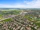 Panoramic aerial view showcasing a suburban neighborhood with lush greenery, mature trees, and a distant lake at 15756 E Aberdeen Ave, Centennial, CO 80016