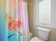 Bathroom with a colorful unicorn themed shower curtain and decorative toilet seat cover at 15756 E Aberdeen Ave, Centennial, CO 80016