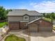 Two-story brick and siding home featuring an attached two car garage and a spacious backyard with lush landscaping at 15756 E Aberdeen Ave, Centennial, CO 80016