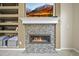 Close-up of a modern fireplace with a decorative tile surround and a mantle with a wall-mounted television at 15756 E Aberdeen Ave, Centennial, CO 80016