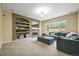 Inviting living room with built-in shelving, a fireplace, and a large window overlooking the backyard at 15756 E Aberdeen Ave, Centennial, CO 80016