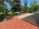 Backyard features gravel area accented by a rustic wood fence and mature trees at 7079 Estes Dr, Arvada, CO 80004