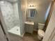 Updated bathroom with a marbled tile shower, vanity with storage, and a modern light fixture at 7079 Estes Dr, Arvada, CO 80004