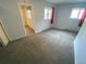 Bedroom with gray carpeting, two windows, and doorway to an adjacent room at 7079 Estes Dr, Arvada, CO 80004