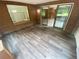 Bright sunroom with wood-look floors, brick accent walls, and sliding glass doors at 7079 Estes Dr, Arvada, CO 80004