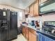 Practical kitchen with granite counters, wood cabinets, and black refrigerator at 1265 Colorado Blvd # 7, Denver, CO 80206