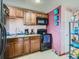 Functional kitchen with granite countertops, wooden cabinets, and black appliances at 1265 Colorado Blvd # 7, Denver, CO 80206