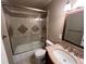 Bathroom with decorative vanity, framed mirror, and tiled shower-tub with glass doors at 6085 Simms St, Arvada, CO 80004